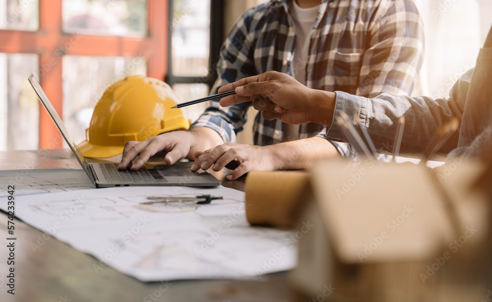 Image of two unknow people discussing a set of building plans at a jobsite.